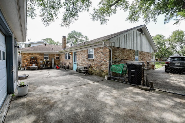 5423 Willow Creek Way, Houston, TX 77017 - rear view of house featuring brick siding, a chimney, board and batten siding, a patio, and a gate
