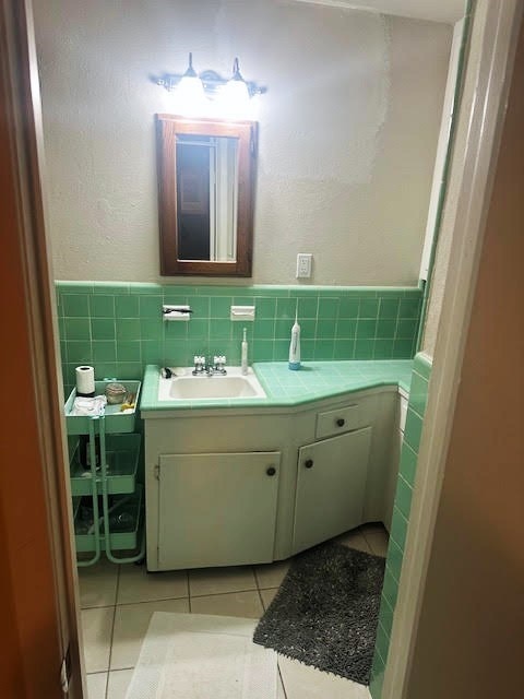 5423 Willow Creek Way, Houston, TX 77017 - bathroom with vanity, tile patterned flooring, tile walls, and wainscoting