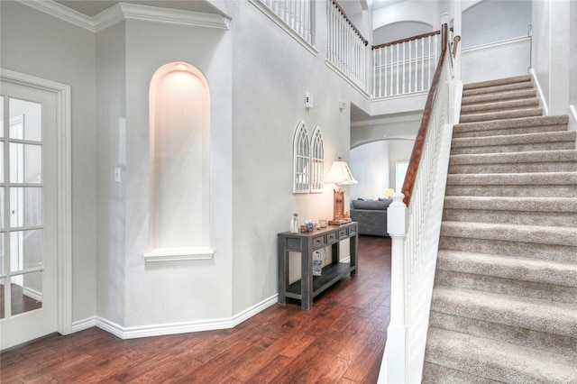 8507 Marchelle Ln, Spring, TX 77379 - staircase featuring wood finished floors, arched walkways, baseboards, ornamental molding, and a high ceiling