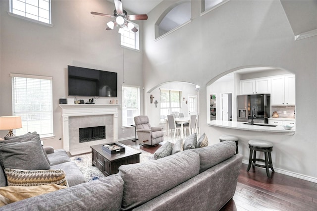 8507 Marchelle Ln, Spring, TX 77379 - living room with a high ceiling, a ceiling fan, arched walkways, dark wood-type flooring, and a premium fireplace