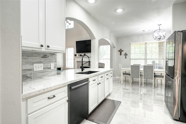 8507 Marchelle Ln, Spring, TX 77379 - kitchen featuring appliances with stainless steel finishes, a sink, backsplash, light stone countertops, and white cabinets