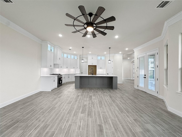 258 Monterrey Rd, Montgomery, TX 77356 - kitchen featuring stainless steel range with gas cooktop, ornamental molding, baseboards, a ceiling fan, and light countertops