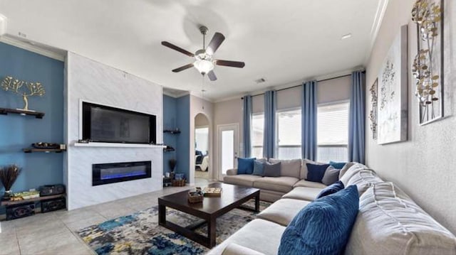 3515 Cactus Field Ln, Katy, TX 77449 - living area featuring arched walkways, ceiling fan, plenty of natural light, crown molding, and a glass covered fireplace