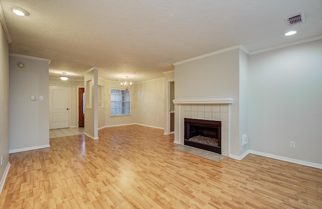 10829 E Linwood Dr, La Porte, TX 77571 - unfurnished living room featuring light wood-style floors, a chandelier, baseboards, crown molding, and a tile fireplace
