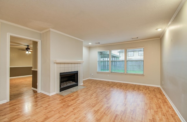 10829 E Linwood Dr, La Porte, TX 77571 - unfurnished living room featuring wood finished floors, a tile fireplace, baseboards, ceiling fan, and crown molding