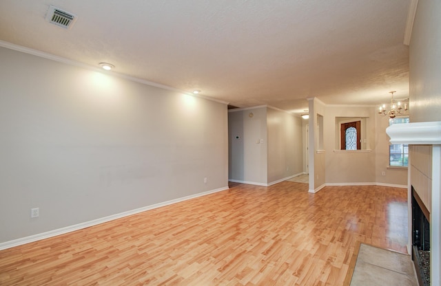 10829 E Linwood Dr, La Porte, TX 77571 - unfurnished living room with light wood-style floors, crown molding, a chandelier, baseboards, and a textured ceiling