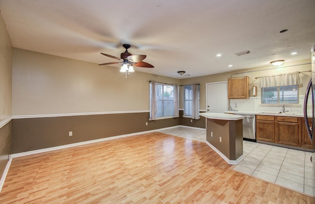 10829 E Linwood Dr, La Porte, TX 77571 - kitchen with dishwasher, light wood finished floors, ceiling fan, a sink, and light countertops