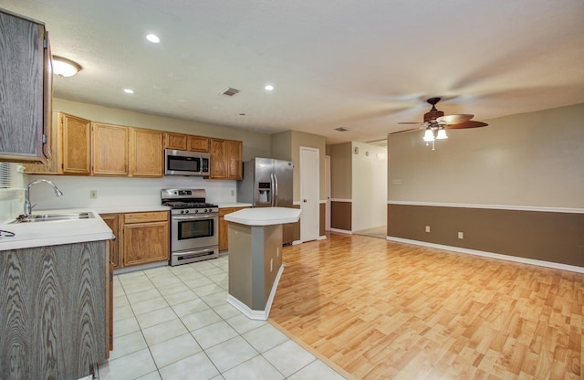 10829 E Linwood Dr, La Porte, TX 77571 - kitchen featuring appliances with stainless steel finishes, a sink, ceiling fan, a kitchen island, and light countertops