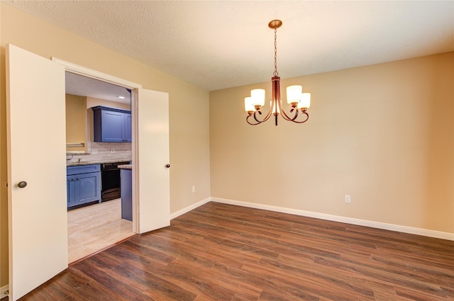 24014 Whitefield Ln, Katy, TX 77493 - unfurnished room featuring dark wood finished floors, a chandelier, and baseboards