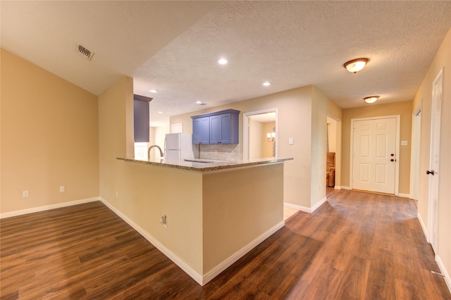 24014 Whitefield Ln, Katy, TX 77493 - kitchen with freestanding refrigerator, dark wood-type flooring, baseboards, light stone countertops, and recessed lighting