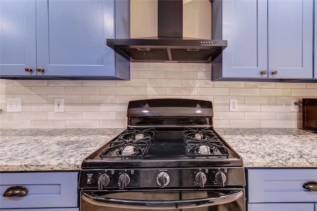 24014 Whitefield Ln, Katy, TX 77493 - kitchen featuring gas stove, wall chimney range hood, backsplash, blue cabinets, and light stone countertops