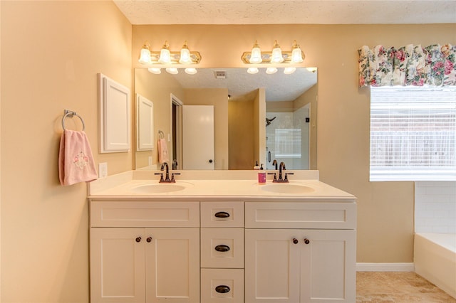 24014 Whitefield Ln, Katy, TX 77493 - bathroom with double vanity, a shower, a bath, a textured ceiling, and baseboards