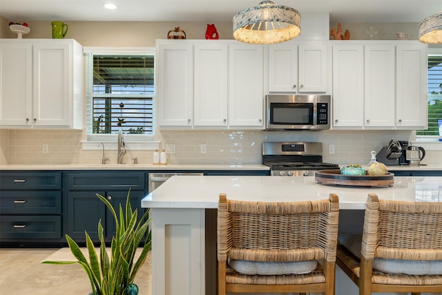 5292 Horseshoe Dr, Anderson, TX 77830 - kitchen featuring appliances with stainless steel finishes, a sink, white cabinetry, a breakfast bar, and recessed lighting