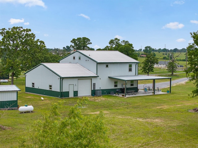 5292 Horseshoe Dr, Anderson, TX 77830 - back of house featuring a yard, metal roof, a garage, a patio area, and central AC unit