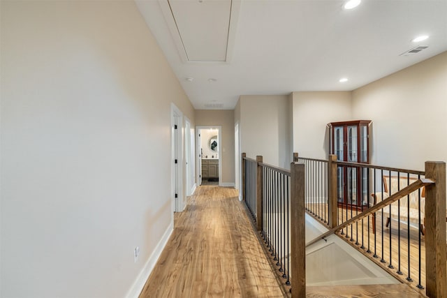 5292 Horseshoe Dr, Anderson, TX 77830 - hallway with an upstairs landing, attic access, light wood-type flooring, baseboards, and recessed lighting