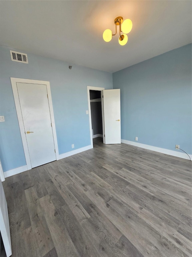 7700 Seawall Blvd Unit 409, Galveston, TX 77551 - unfurnished bedroom featuring wood finished floors, a chandelier, and baseboards