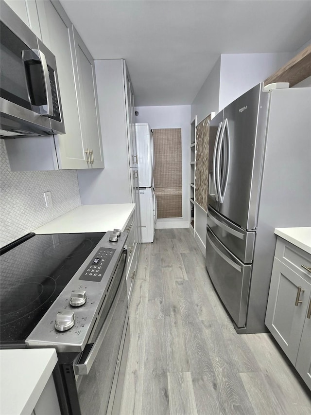7700 Seawall Blvd Unit 409, Galveston, TX 77551 - kitchen with appliances with stainless steel finishes, gray cabinets, light wood-style flooring, and light countertops