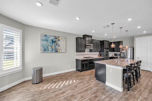 5803 Platinum Lakes Ct, Rosenberg, TX 77469 - kitchen featuring appliances with stainless steel finishes, plenty of natural light, light wood finished floors, baseboards, and recessed lighting
