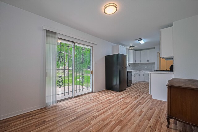 1029 Dolly Wright St, Houston, TX 77088 - kitchen with black appliances, light wood finished floors, decorative backsplash, and white cabinets