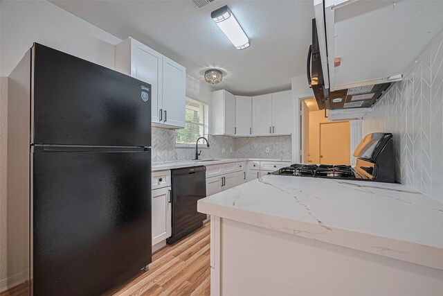 1029 Dolly Wright St, Houston, TX 77088 - kitchen featuring black appliances, light wood finished floors, white cabinets, backsplash, and light stone counters