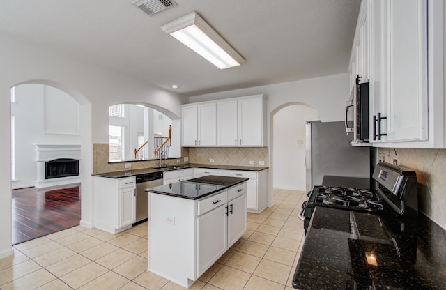 6018 Lamb Crk, Missouri City, TX 77459 - kitchen featuring appliances with stainless steel finishes, light tile patterned flooring, a center island, tasteful backsplash, and a sink