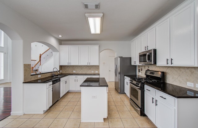 6018 Lamb Crk, Missouri City, TX 77459 - kitchen with stainless steel appliances, a sink, a center island, arched walkways, and recessed lighting