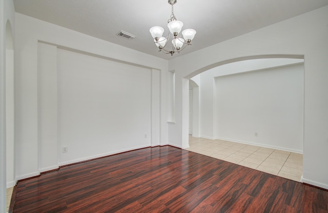 6018 Lamb Crk, Missouri City, TX 77459 - spare room featuring arched walkways, a chandelier, wood finished floors, and baseboards