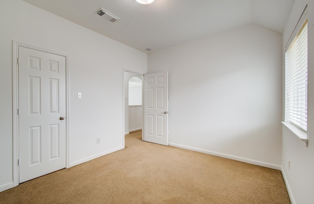 6018 Lamb Crk, Missouri City, TX 77459 - unfurnished bedroom featuring light carpet, baseboards, lofted ceiling, and arched walkways