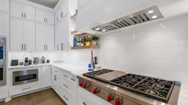 1410 Indiana St, Houston, TX 77006 - kitchen with wall chimney exhaust hood, gas stovetop, stainless steel microwave, white cabinets, and light stone countertops