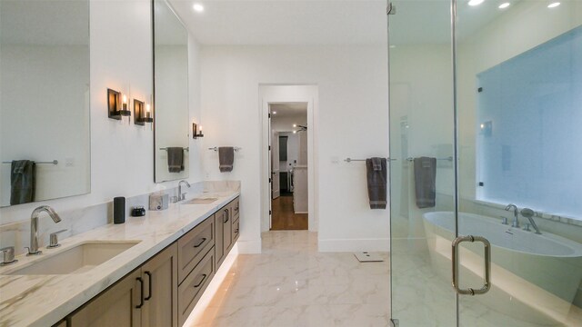 1410 Indiana St, Houston, TX 77006 - bathroom with marble finish floors, a soaking tub, a shower stall, double vanity, and baseboards
