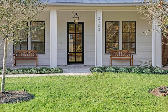 1732 Libbey Dr, Houston, TX 77018 - view of exterior entry with covered porch, a standing seam roof, metal roof, and a yard