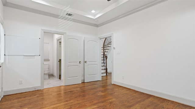 1415 W 21st St Unit A, Houston, TX 77008 - unfurnished bedroom featuring wood finished floors, recessed lighting, ensuite bathroom, a raised ceiling, and baseboards