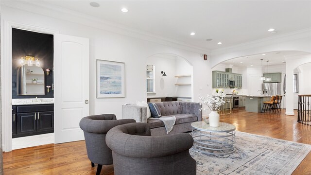 1415 W 21st St Unit A, Houston, TX 77008 - living room featuring crown molding, arched walkways, light wood-style flooring, and recessed lighting