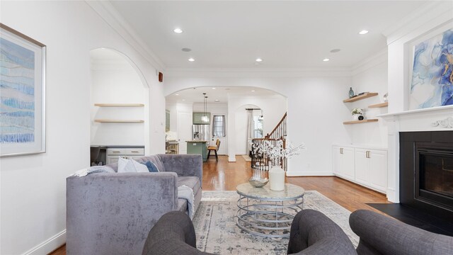 1415 W 21st St Unit A, Houston, TX 77008 - living room with arched walkways, ornamental molding, a fireplace with flush hearth, light wood-style floors, and stairs