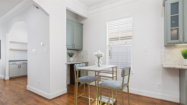 1415 W 21st St Unit A, Houston, TX 77008 - dining room with arched walkways, crown molding, wood finished floors, and baseboards