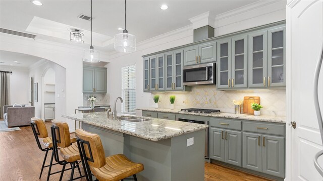 1415 W 21st St Unit A, Houston, TX 77008 - kitchen with a sink, stainless steel microwave, gray cabinetry, arched walkways, and backsplash