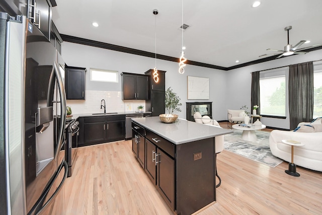1544 W 23rd St Unit B, Houston, TX 77008 - kitchen featuring appliances with stainless steel finishes, open floor plan, a sink, ornamental molding, and plenty of natural light