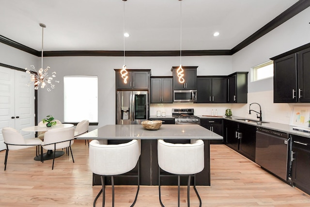 1544 W 23rd St Unit B, Houston, TX 77008 - kitchen featuring stainless steel appliances, a sink, ornamental molding, a breakfast bar, and dark cabinets
