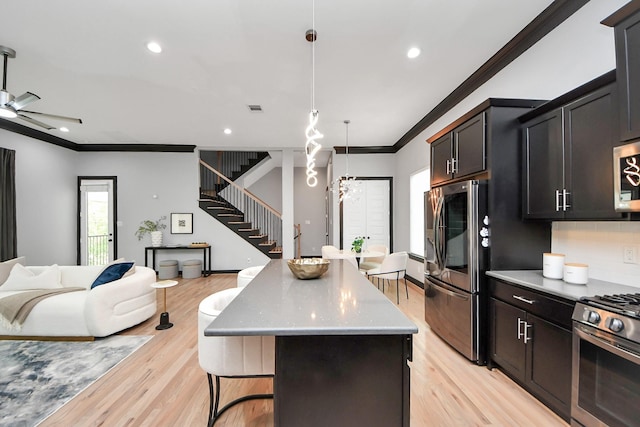 1544 W 23rd St Unit B, Houston, TX 77008 - kitchen with stainless steel appliances, ornamental molding, open floor plan, a center island, and light wood finished floors
