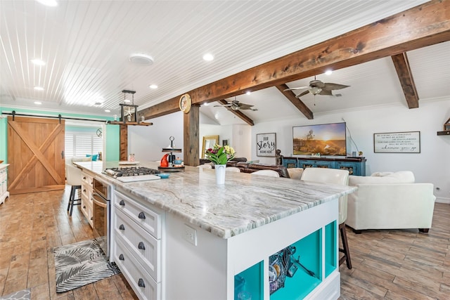 1310 Hickory Ln, Houston, TX 77339 - kitchen with a barn door, stainless steel oven, white cabinetry, a breakfast bar, and light wood-type flooring