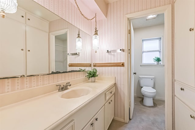 15419 Diana Ln, Houston, TX 77062 - bathroom featuring wallpapered walls, toilet, vanity, and baseboards