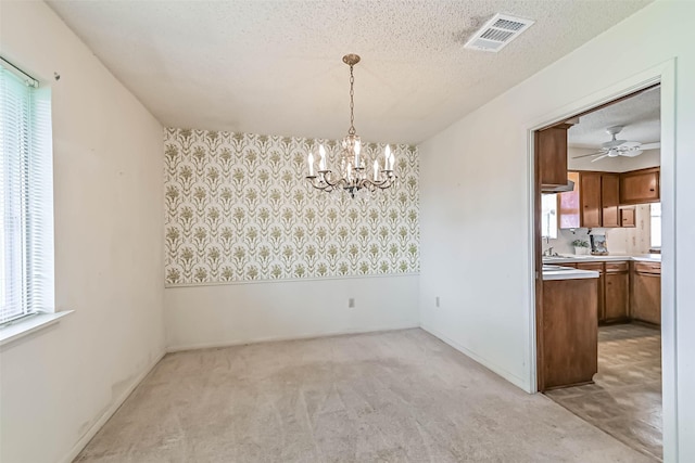 15419 Diana Ln, Houston, TX 77062 - unfurnished dining area featuring a chandelier, light colored carpet, a textured ceiling, a ceiling fan, and wallpapered walls