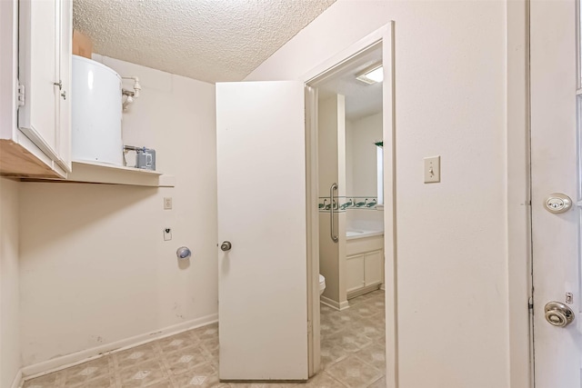 15419 Diana Ln, Houston, TX 77062 - laundry room with water heater, a textured ceiling, and baseboards