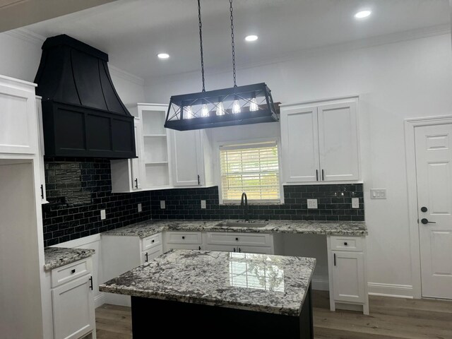 4120 Buffalo St, Beaumont, TX 77703 - kitchen featuring a sink, crown molding, light stone countertops, white cabinets, and wood finished floors