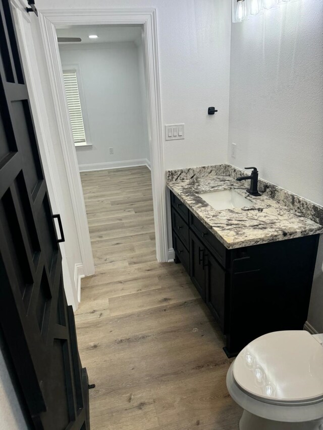4120 Buffalo St, Beaumont, TX 77703 - bathroom with wood finished floors, vanity, baseboards, and toilet