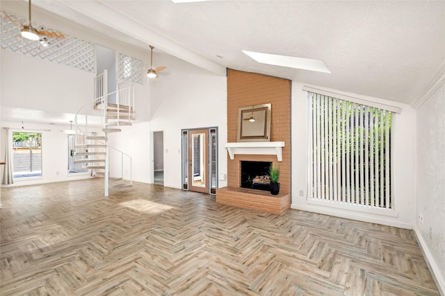 707 Center Hill Dr, Houston, TX 77079 - unfurnished living room featuring stairs, baseboards, high vaulted ceiling, a brick fireplace, and a skylight