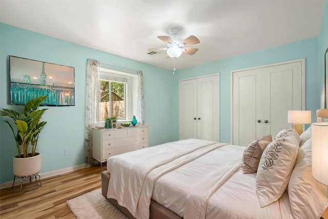 707 Center Hill Dr, Houston, TX 77079 - bedroom featuring light wood-style flooring, two closets, baseboards, and ceiling fan