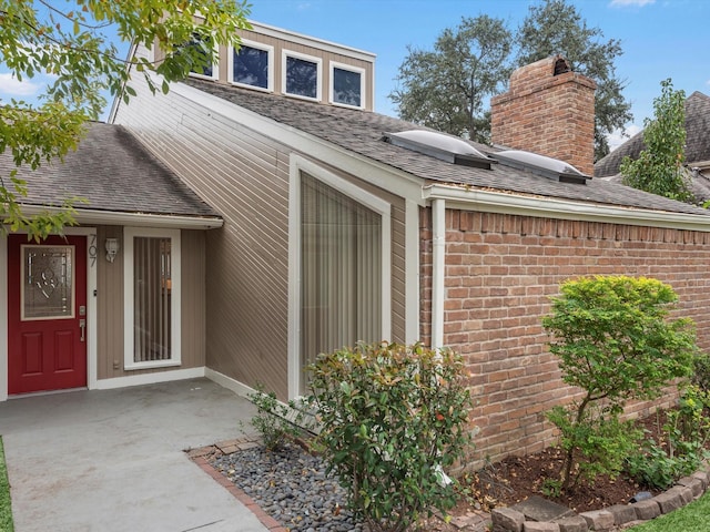 707 Center Hill Dr, Houston, TX 77079 - view of exterior entry featuring brick siding and a shingled roof
