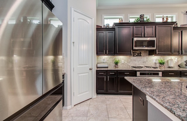 3111 Jane Way, Richmond, TX 77406 - kitchen with stainless steel appliances, crown molding, backsplash, dark stone countertops, and light tile patterned floors
