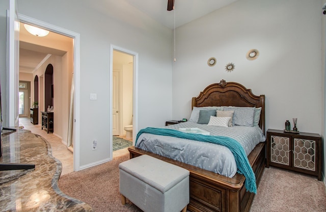 3111 Jane Way, Richmond, TX 77406 - bedroom with light carpet, arched walkways, ensuite bathroom, and baseboards